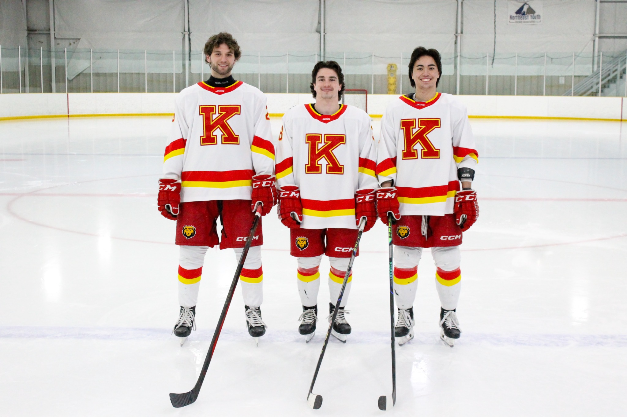 Stefan Lakoseljac with teammates in white K hockey uniforms